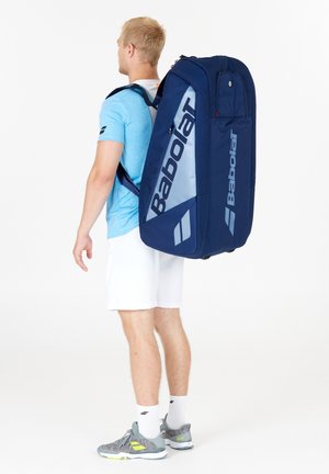 Zaino sportivo blu navy con forma rettangolare, grande scomparto principale, spallacci imbottiti e logo Babolat in blu chiaro in evidenza.