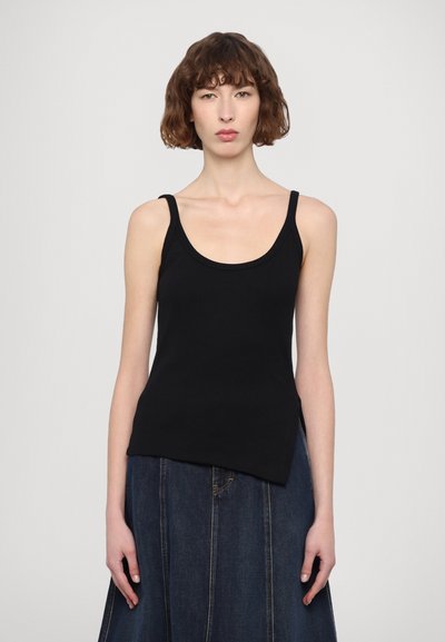 Black ribbed tank top with wide straps, featuring a rounded neckline and a straight hem, paired with a long denim skirt with vertical seams.