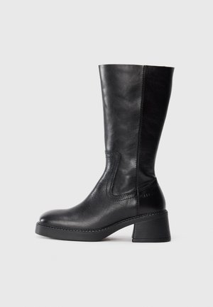 Bota de cuero negra hasta la mitad de la pantorrilla con tacón cuadrado y punta redonda, costuras visibles a lo largo de los lados y acabado suave y pulido.