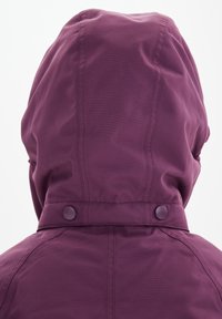 Violetti hupparitakki, jossa on sileä pinta, näkyvät saumat ja kaksi napinpainiketta kaulassa. Pehmeä, kevyt kangas.