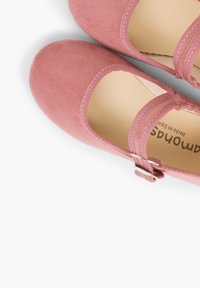 Ballerine in suede rosa con punta arrotondata e una fascia sopra l'instep, con una piccola fibbia argentata e un interno liscio.