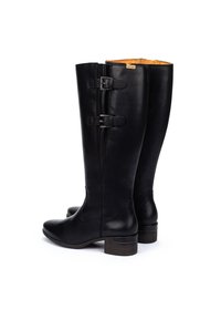 Botas de cuero negro hasta la rodilla con doble hebilla, punta afilada y tacón texturizado. El interior presenta un forro en contraste de color marrón claro.