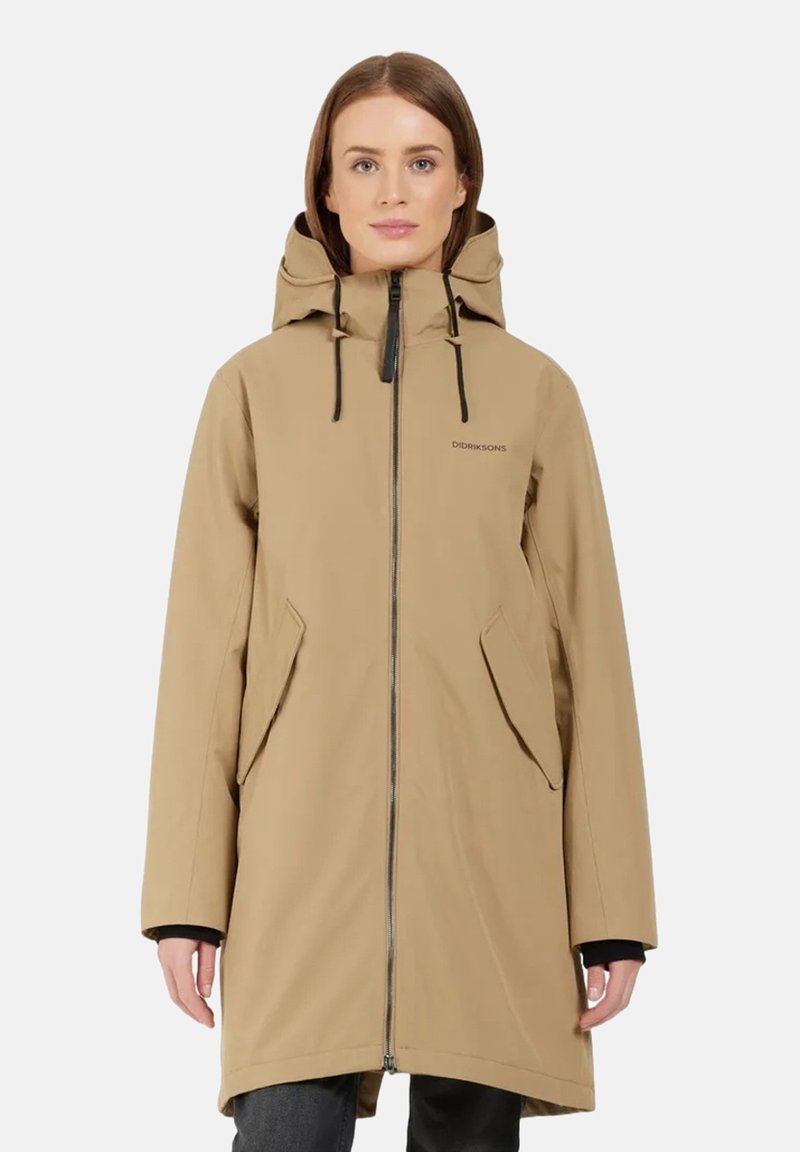 Beiger wasserdichter langer Mantel mit einem Frontreißverschluss, zwei seitlichen Taschen, verstellbarem Kapuzen und schwarzen Kordeln. Mit einer glatten, strapazierfähigen Textur.