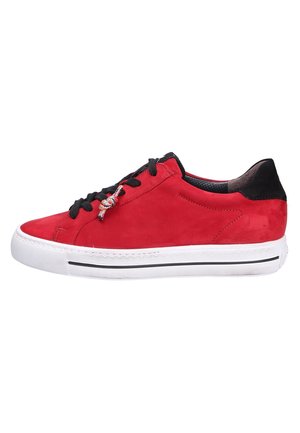 Zapatilla deportiva roja de caña baja con cordones negros y lengüeta en el talón, suela de goma blanca con una franja negra y un adorno decorativo en los cordones al costado.