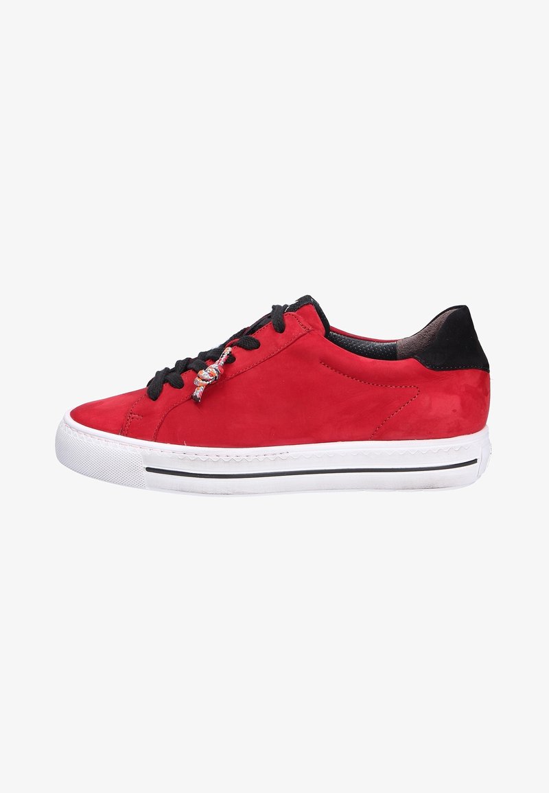Baskets basses rouges avec lacets noirs et languette au talon, semelle en caoutchouc blanche avec une bande noire, et un charme décoratif en lacet sur le côté.