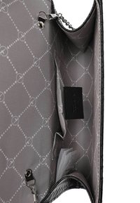 Interno di una borsa in pelle artificiale nera con fodera grigia a motivo. Le caratteristiche includono una tasca con zip, slot per carte e un'etichetta nera. Manico a catena visibile.