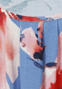 Bloemenpatroon top met blauwe, roze en rode tinten, met een zachte textuur en geplooid ontwerp rond de halslijn.