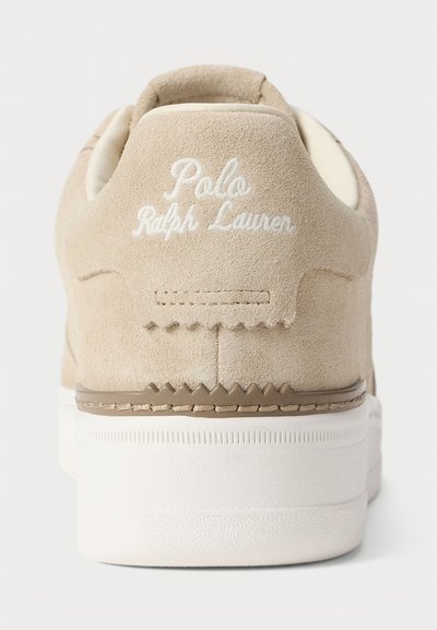 Baskets en daim beige avec des coutures blanches, arborant "Polo Ralph Lauren" brodé au niveau du talon et une semelle en caoutchouc texturé.