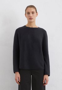 Schwarzer Pullover aus weichem Stoff, mit runder Halslinie und langen Ärmeln. Schlichtes Design mit geradem Schnitt und ohne sichtbare Verzierungen.