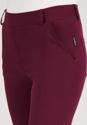 Bordeaux stretchy broek met een zachte textuur, voorzien van een zijzak, ceintuurlussen en een klein label met de tekst "JE M'APPELLE."