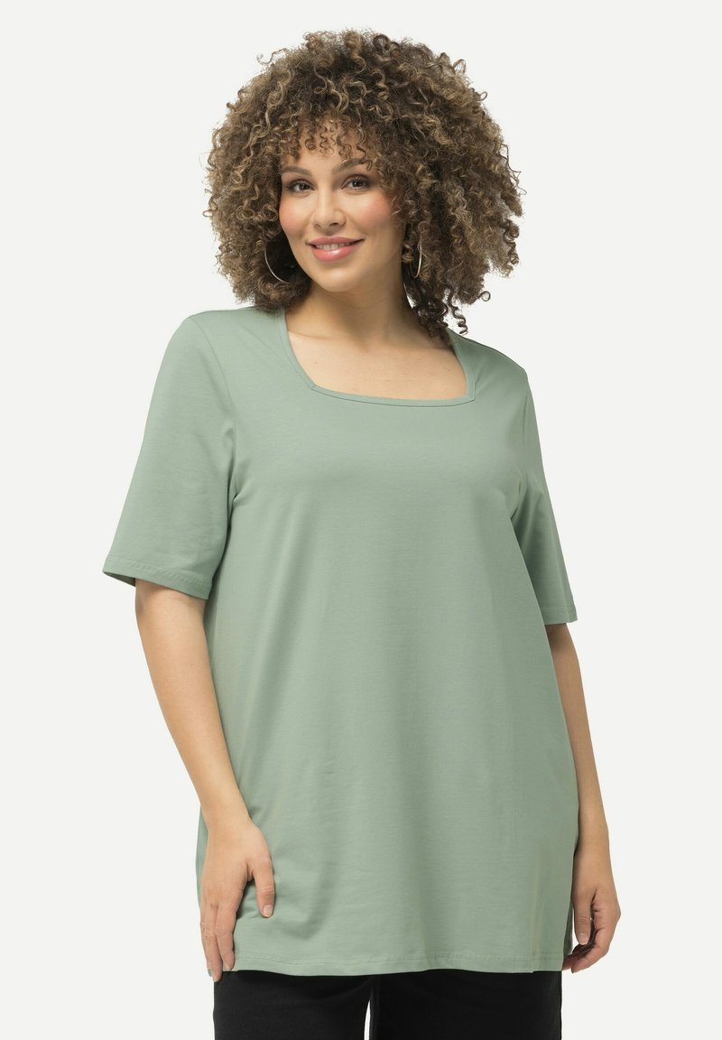 T-shirt verde chiaro con scollatura quadrata e maniche corte. Realizzato in tessuto morbido; vestibilità ampia con bordo inferiore curvo.