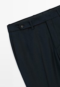 Donkerblauwe broek van gladde stof, met een enkele zwarte knop aan de taille en zijzakken, in een slim fit ontwerp.