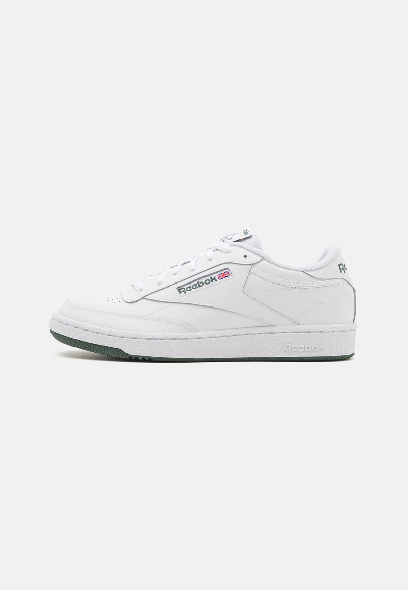 Bijele kožne tenisice s teksturiranom površinom, zelenim gumiranim potplatom i Reebok logotipom sa strane. Imaju klasično vezanje i podstavljeni ovratnik.