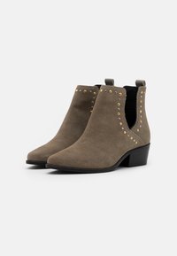 Stivali ankle in suede verde oliva con punta affilata e tacco a blocco basso, caratterizzati da decorazioni in perline argento e oro lungo i lati.