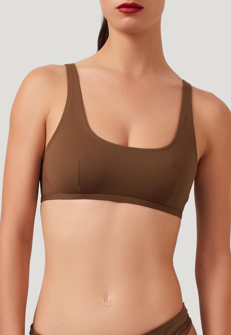 Reggiseno sportivo marrone, senza cuciture, con scollatura quadrata, spalline larghe e design minimalista, realizzato in materiale liscio ed elastico.