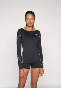 Svart atletisk långärmad topp gjord av stretchnylon med reflexsömmar och rund halsringning, tillsammans med svarta shorts.