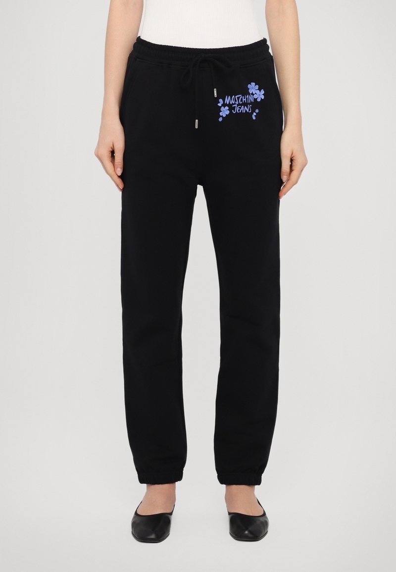 Musta collegehousut, joissa on joustava vyötärö, narukiinnitys ja sininen kukkakuosiset Moschino Jeans -logot edessä.