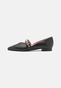 Black leather flats featuring a pointed toe, a strap with metallic studs, and a low, block heel. Smooth texture with minimal design details.