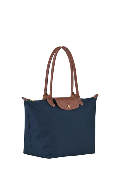 Navy blue nylon tote bag with brown leather handles and a flap closure, featuring gold hardware and a smooth, textured finish.