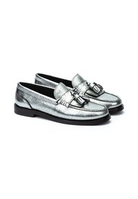 Mocasines metálicos plateados con un acabado texturizado, que presentan acentos de hardware decorativo y una suela negra suave. Diseño clásico con perfil bajo.