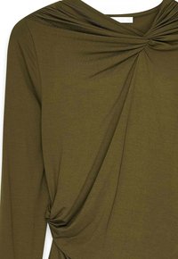 Oliveza zaļa blūze, kas izgatavota no mīkstas auduma, ar pagrieztu dizainu apkakles daļā un plūstošu tekstūru tuvumā viduklim. Iekļautas garas piedurknes.