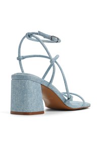 Sandali con tacco alto in denim blu, con cinturini e tacco a blocco, caratterizzati da un tessuto testurizzato e una suola liscia marrone.