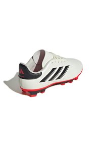 Botín de fútbol blanco con rayas negras y suela roja. Material de cuero liso, puntera redondeada, cuello acolchado y acento negro en el talón.