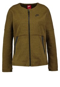 Chaqueta con cremallera de Nike en verde oliva, con cuello redondeado, mangas largas y bolsillos laterales con acentos grises. Textura de tela suave.