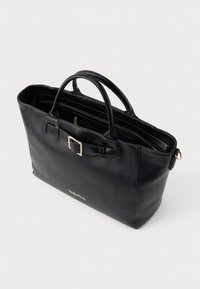Black leather tote bag with dual handles, gold hardware accents, rectangular shape, and a visible logo on the front. Features multiple interior pockets.