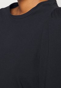 Schwarz, leichtes Stoff-T-Shirt mit rundem Halsausschnitt und dezenten Puffärmel-Details, glatte Textur und ohne sichtbare Muster oder Akzente.