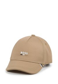 Cappello da baseball beige in tessuto, con visiera curva e logo ricamato "BOSS" in bianco, con un accento nero sul lato.