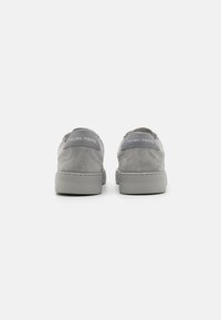 Sneaker in suede grigio a profilo basso, dotate di suola in gomma liscia e un'apposita etichetta sul tallone. Design minimalista con accenti sobrii.