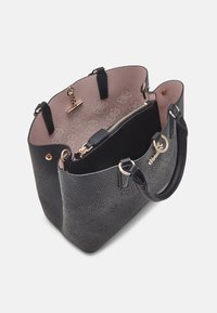 Sac cabas noir texturé avec un intérieur rose clair. Il comporte une quincaillerie dorée, deux poignées et une pochette intérieure zippée.