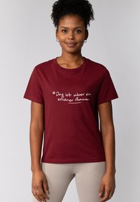 Bordeaux katoenen t-shirt met korte mouwen, voorzien van witte tekst in een handgeschreven stijl. Soepele textuur, klassieke ronde hals ontwerp.