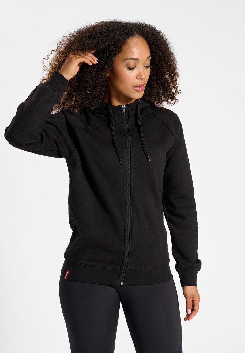 Felpa nera con zip e colletto alto, cordini regolabili, polsini a coste e una piccola etichetta con logo sull'orlo. Tessuto morbido in misto cotone.