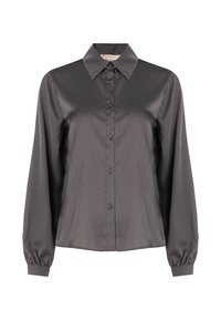 Blusa a righe in bianco e nero con colletto a punta, maniche lunghe, chiusura con bottoni e tessuto testurizzato caratterizzato da sottili linee diagonali.