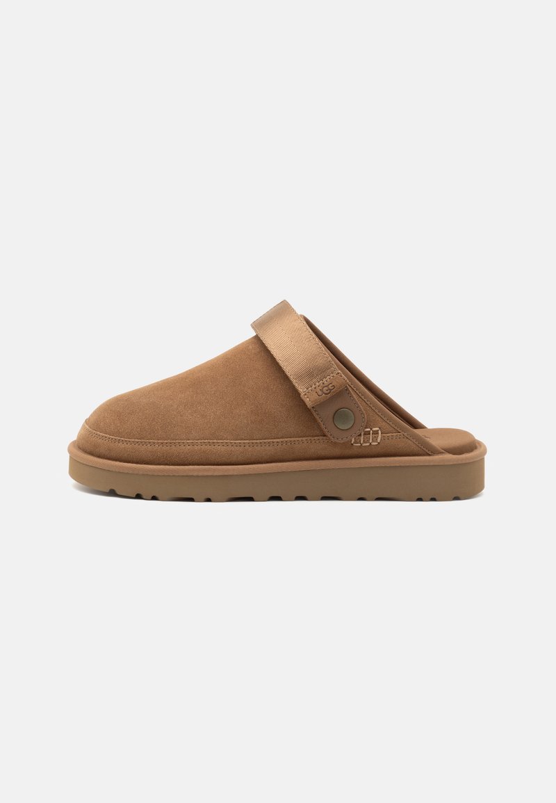 Suede slip-on clogs in tan with a rounded toe and back strap. Rubber sole with textured tread pattern for grip.