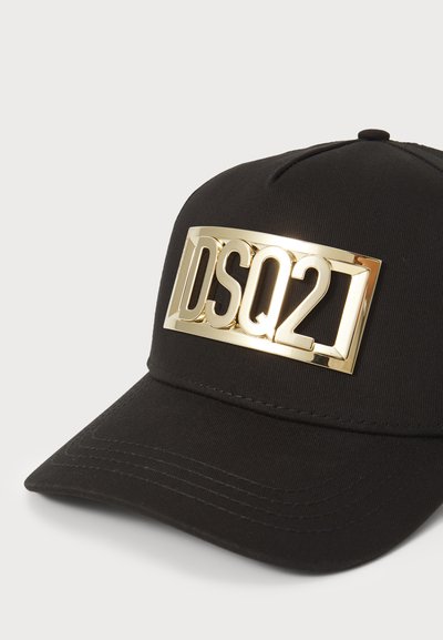 Schwarze Baseballmütze mit einem goldenen Metall-Logo-Schild mit "DSQ21" auf der Vorderseite. Die Mütze hat ein strukturiertes Design und einen gebogenen Schirm.