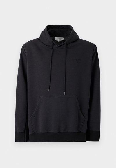 Juodas gobtuvas pagamintas iš minkštos medžiagos, su raišteliu reguliuojamu gobtuvu, priekinė kanga su kišenėmis ir audiniu apdirbtais rankogaliais bei apačia. Tekstūruotas logotipo akcentas krūtinėje.