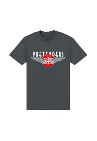 Donkergrijze katoenen t-shirt met de tekst "PRETENDERS" en witte vleugels met een rood cirkelontwerp in het midden. Korte mouwen, ronde hals.