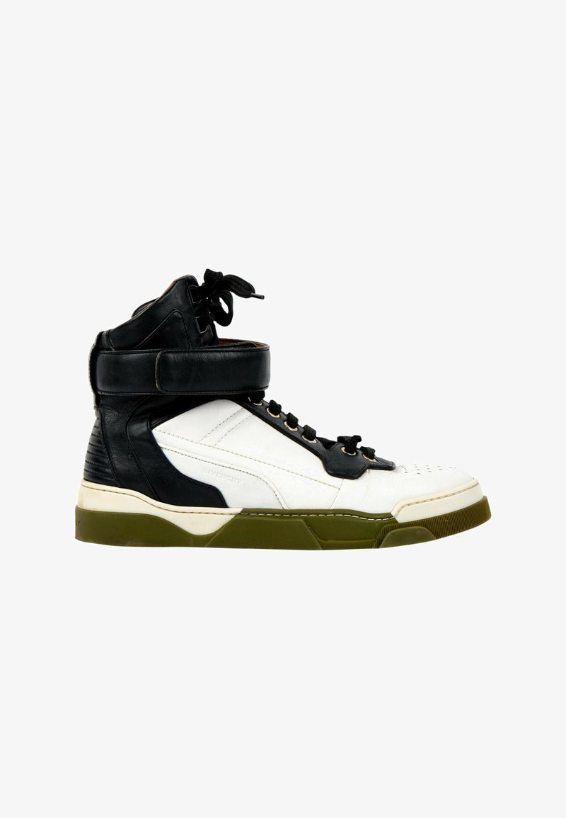 Basket montante en cuir blanc et noir avec semelle vert olive, lacets noirs et large sangle à la cheville pour le maintien.