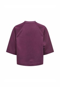 Haut court à manches courtes de couleur violette unie avec des coutures raglan et une coupe décontractée, présenté de l'arrière sur un fond blanc.