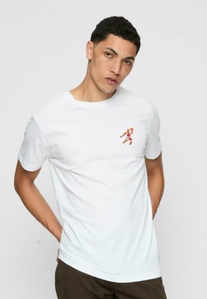 Hvid bomulds T-shirt med et lille pixelkunst grafik af en basketballspiller i orange og brun. Enkel rund hals og korte ærmer.