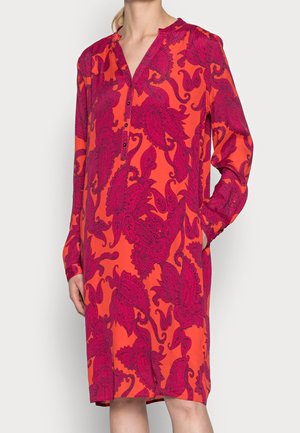 Robe à manches longues en orange vif avec un motif paisley rose foncé, dotée d'un décolleté en V et d'une fermeture à boutons. Fabriquée en tissu léger.