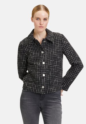 Black and white checkered jacket, textured fabric, button closure, pointed collar, long sleeves, and front pockets.