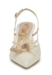 Scarpa slingback realizzata in satin con punta affusolata, di colore crema, decorata con un dettaglio floreale trasparente e una fascia con fibbia minimalista.