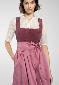 Das Kleid verfügt über ein Korpus aus tiefburgunderfarbener Cord-Textur, einen Reißverschluss vorne und einen fließenden pinken Satinkleid mit einer Schleife an der Taille sowie Taschen an der Seite.