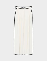 Κρεμ παντελόνια με φαρδιά μπατζάκια και μαύρη επένδυση κατά μήκος της μέσης, των τσεπών, των πλευρών και των τελειωμάτων, με πιέτες στο μπροστινό μέρος και κρυφό κουμπί στο μπροστινό κλείσιμο.