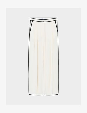 Kreemikad laia säärega püksid musta ääristusega vöökohal, taskutel, külgedel ja säärepikkus, ees voldid ja varjatud eesmine nööpidega kinnis.