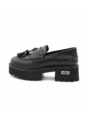 Mocassins en cuir noir avec une semelle plateforme épaisse, des franges décoratives et des détails cousus. Accent en métal argenté sur le côté.